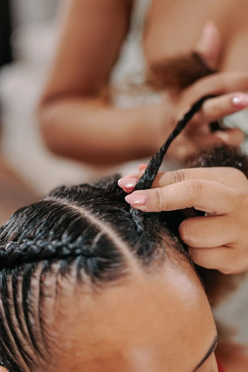 Coiffeuse réalisant des tresses